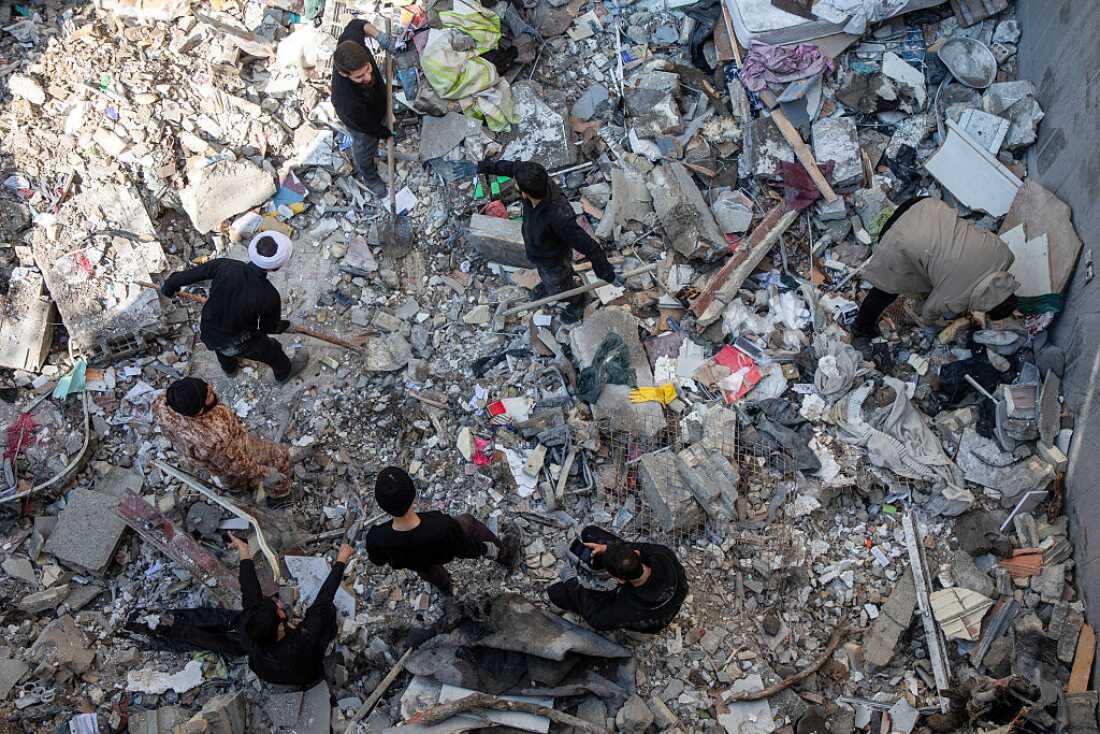 People sift through rubble in the aftermath of a drone attack on a residential building in which one civilian was killed on March 31, 2026 in eastern Tehran, Iran.