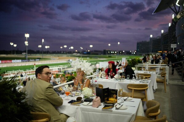 Racegoers dine at in the grandstand during the Dubai World Cup at Meydan Racecourse in Dubai, United Arab Emirates, Saturday, March 28, 2026. (AP Photo/Altaf Qadri)