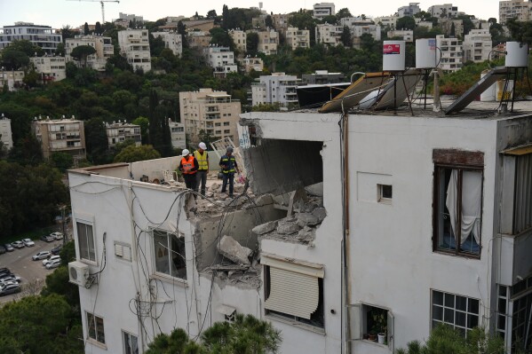 Israeli authorities inspect a damaged house following an Iranian missile strike in Haifa, Israel, Monday, March 30, 2026. (AP Photo/Ariel Schalit)