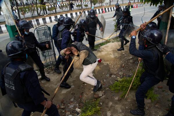 Police officers use batons on a supporter of former Prime Minister Khadga Prasad Oli during a protest following his arrest over deaths linked to last year September protests, in Kathmandu, Nepal, Saturday, March 28, 2026. (AP Photo/Niranjan Shrestha)