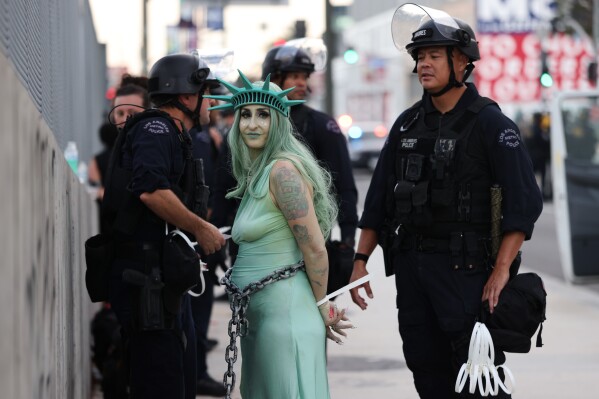 Police arrest a protestor dressed as the Statue of Liberty in downtown Los Angeles after the "No Kings" rally Saturday, March 28, 2026. (AP Photo/Jill Connelly)