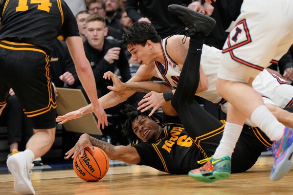 Iowa's Tavion Banks (6) and Illinois' Andrej Stojakovic battle for a loose ball during the first half of an Elite Eight game in the NCAA college basketball tournament Saturday, March 28, 2026, in Houston. (AP Photo/Ashley Landis)