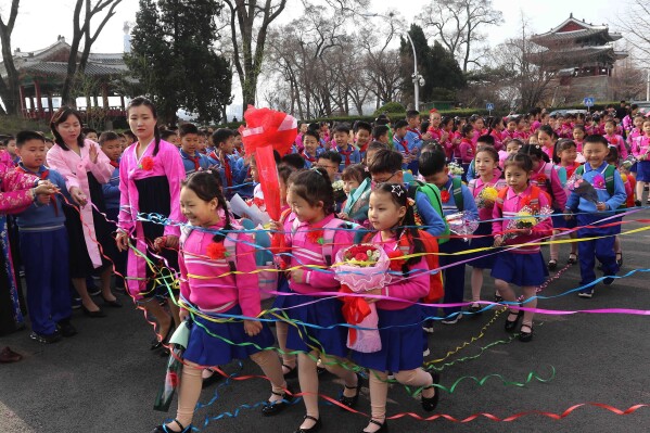 Newly enrolled pupils are welcomed by students, teachers and others during a school-opening ceremony at Kim Song Ju Primary School in Pyongyang, North Korea Wednesday, April 1, 2026. (AP Photo/Cha Song Ho)