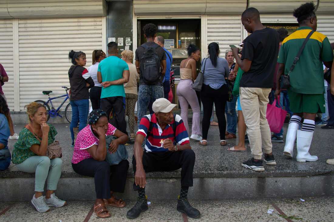 People wait their turn to enter a bank in Havana, Cuba, Wednesday, April 1, 2026.