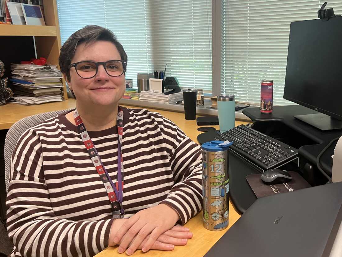 This photo shows Carla Wale, the director of the Gallagher Law Library at the University of Washington School of Law, sitting at a computer desk.