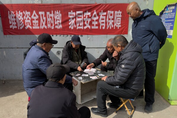 Elderly men play cards at a residential complex for former and current coal miners in Datong, China, Saturday, March 14, 2026. (AP Photo/Ng Han Guan)