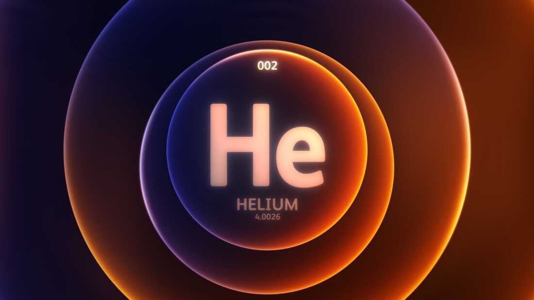 The letters H (uppercase) and e (lowercase) are large and light yellowish pink inside of a dark blue and orange circle, which is layered over two larger circles of the same coloring. Below the letter the word HELIUM is written. Below that is the number4.0026. At the top of the first circle is the number 0.02.