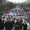 A crowd of people are shown marching down an avenue in a wide-angle view. A large banner that says "March for Life" is visible in front of part of the crowd.