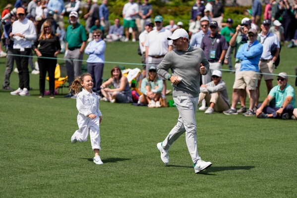 Rory McIlroy, right, runs with his daughter, Poppy, during par-3 contest ahead of the Masters golf tournament at the Augusta National Golf Club, Wednesday, April 8, 2026, in Augusta, Ga. (AP Photo/Ashley Landis, File)