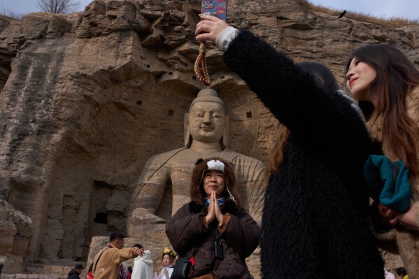 Tourists visit the Yungang Grottoes in Datong, China, Friday, March 13, 2026. (AP Photo/Ng Han Guan, File)