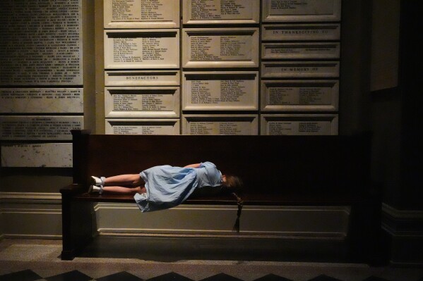 A young worshipper rests on a bench outside the nave of the cathedral during an Easter vigil at St. James Cathedral, Saturday, April 4, 2026, in Seattle. (AP Photo/Lindsey Wasson, File)
