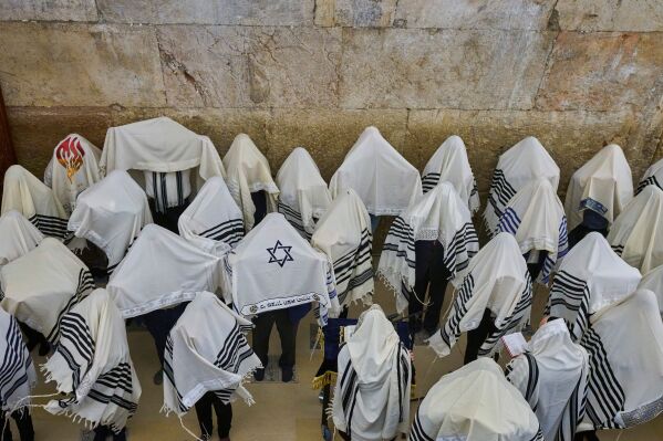 Ultra-Orthodox Jewish men pray during the priestly blessing on the Jewish holiday of Passover at the Western Wall, the holiest site where Jews can pray, in Jerusalem's Old City, largely empty due to restrictions linked to the Iran war, Sunday, April 5, 2026. (AP Photo/Ohad Zwigenberg, File)