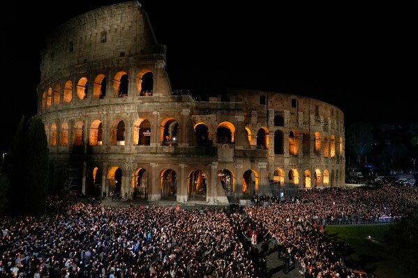 Pope Leo XIV carries a lightweight, 1.5-meter (5-foot) wooden cross during the Via Crucis, the torchlit Good Friday Stations of the Cross procession at the Colosseum in Rome, Friday, April 3, 2026, which symbolically retraces Jesus Christ's steps to his crucifixion on Calvary in Jerusalem. (AP Photo/Gregorio Borgia, File)