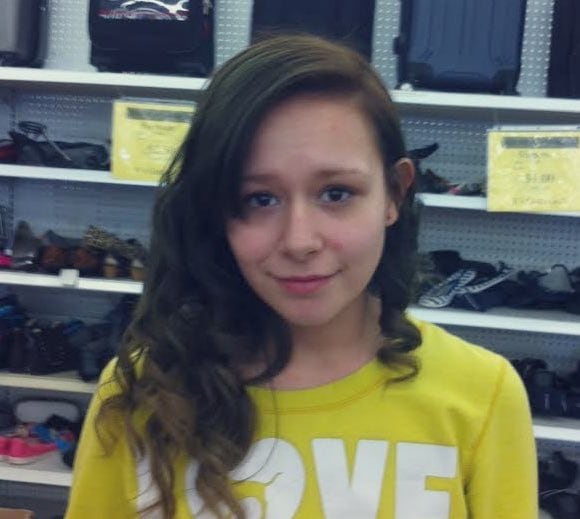 woman stands in store wearing yellow shirt