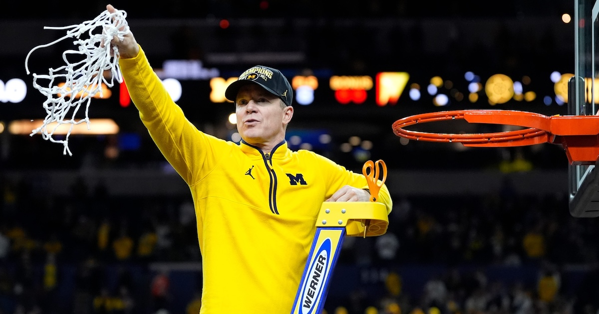 Michigan head coach Dusty May swings the net after winning the NCAA national championship against Connecticut at Lucas Oil Stadium in Indianapolis on Monday, April 6, 2026.