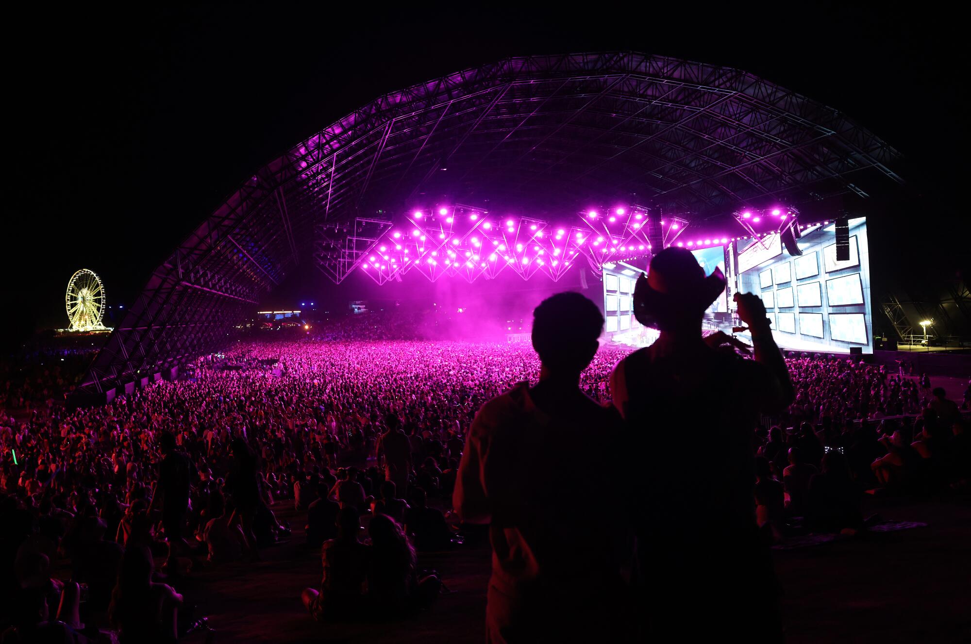 Fans watch Katseye perform on the Sahara stage at night under pink lights.