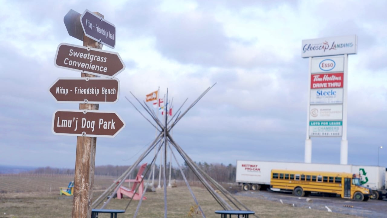 sign posted on a lawn near a school bus