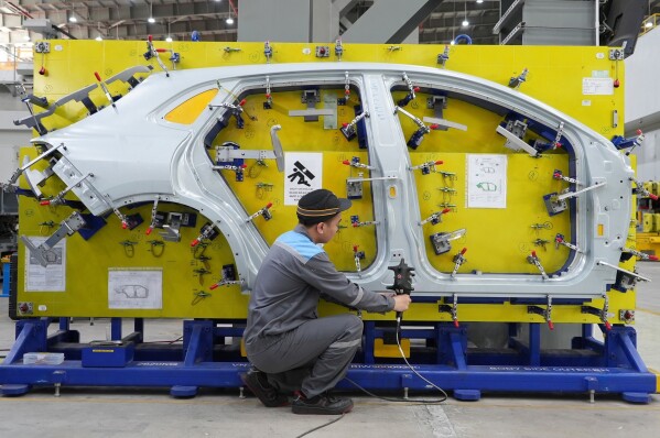 FILE - A worker examines a car frame at a Vinfast factory in Hai Phong, Vietnam, Sept. 29, 2023. (AP Photo/Hau Dinh, File)