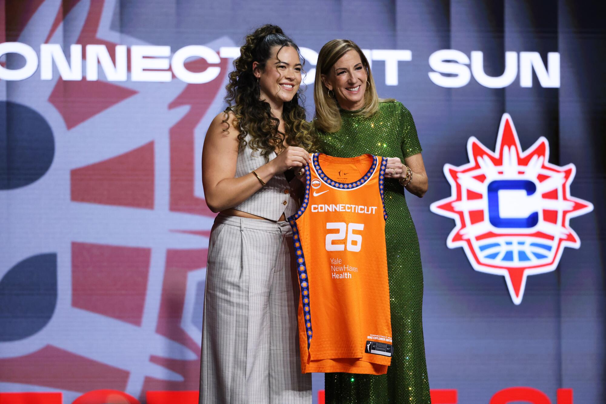 UCLA guard Charlisse Leger-Walker poses with WNBA commissioner Cathy Engelbert after being selected No. 18.