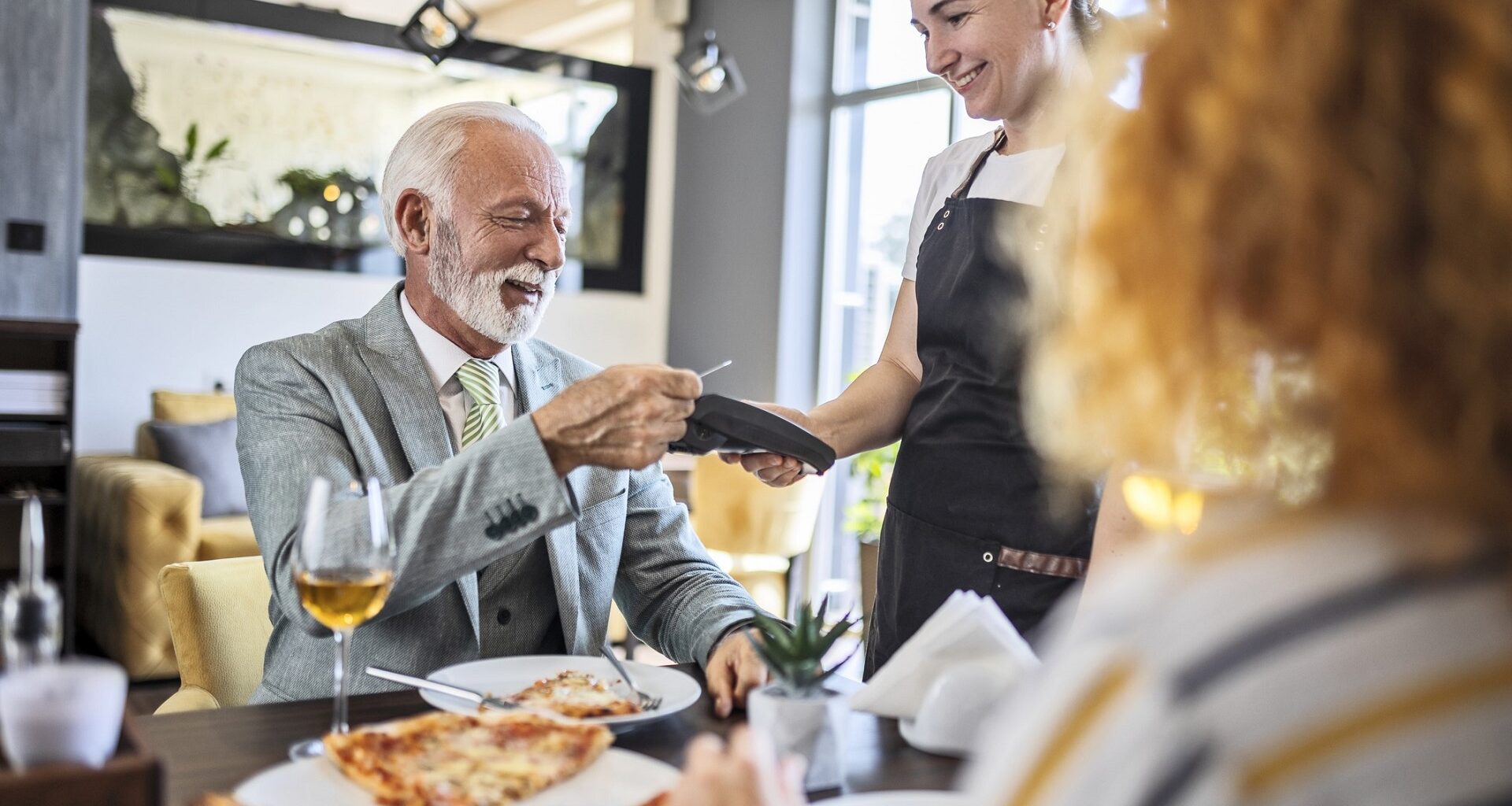 Father having pizza with daughter in restaurant ,paying bill stock photo