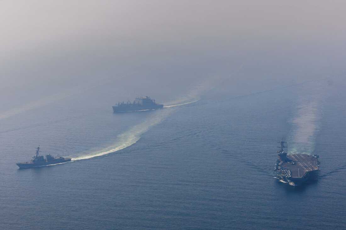 In this aerial photo taken above the Arabian Sea on February 6, the U.S. Navy's aircraft carrier USS Abraham Lincoln sails on the right side of the frame, alongside guided-missile destroyer USS Frank E. Petersen Jr. and dry cargo ship USNS Carl Brashear, which are on the left side of the frame.