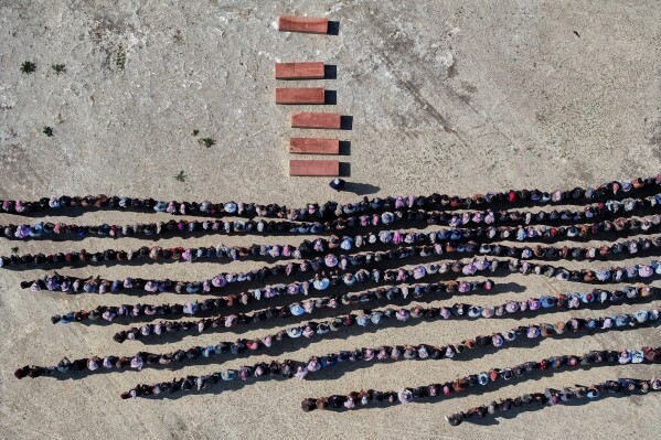 Mourners pray over the six coffins of members of the Al-Jalib family, who were killed Wednesday in Israeli strikes in Beirut, during their funeral in the village of al-Sour, Deir al-Zour province, northeastern Syria, Saturday, April 11, 2026. (AP Photo/Ghaith Alsayed, File)