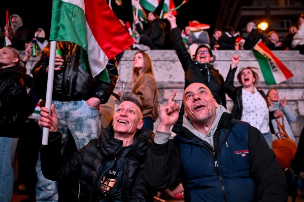 People react in the streets after the announcement of partial results of the Hungarian parliamentary in Budapest, Hungary, Sunday, April 12, 2026. (AP Photo/Denes Erdos, File)
