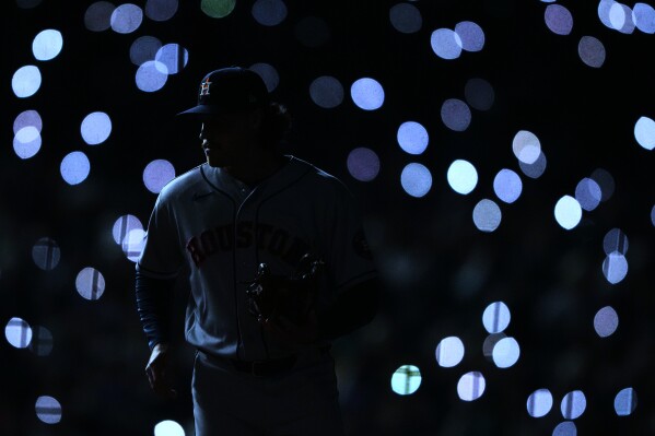 Houston Astros relief pitcher Bryan King warms up before facing the Seattle Mariners as fan turn their phone lights on during the sixth inning of a baseball game, Saturday, April 11, 2026, in Seattle. (AP Photo/Lindsey Wasson, File)