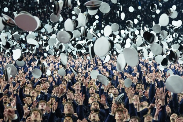New young German police officer trainees throw their hats in the air after taking their oath of service and officially entering the service for security, law and democracy in Cologne, Germany, Wednesday, April 15, 2026. (AP Photo/Martin Meissner, FIle)