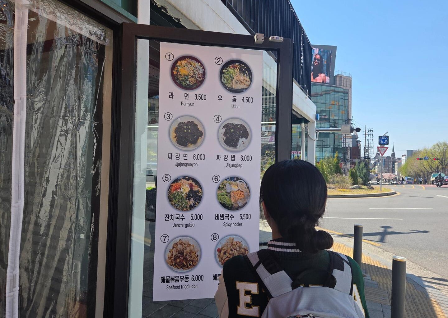 A university student examines a menu outside a restaurant in Seodaemun District, Seoul, April 7. Korea Times photo by Na Min-seo
