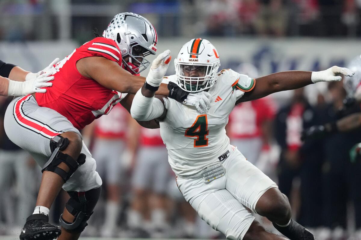 Miami defensive lineman Rueben Bain Jr., right, tries to rush past Ohio State offensive lineman Phillip Daniels.