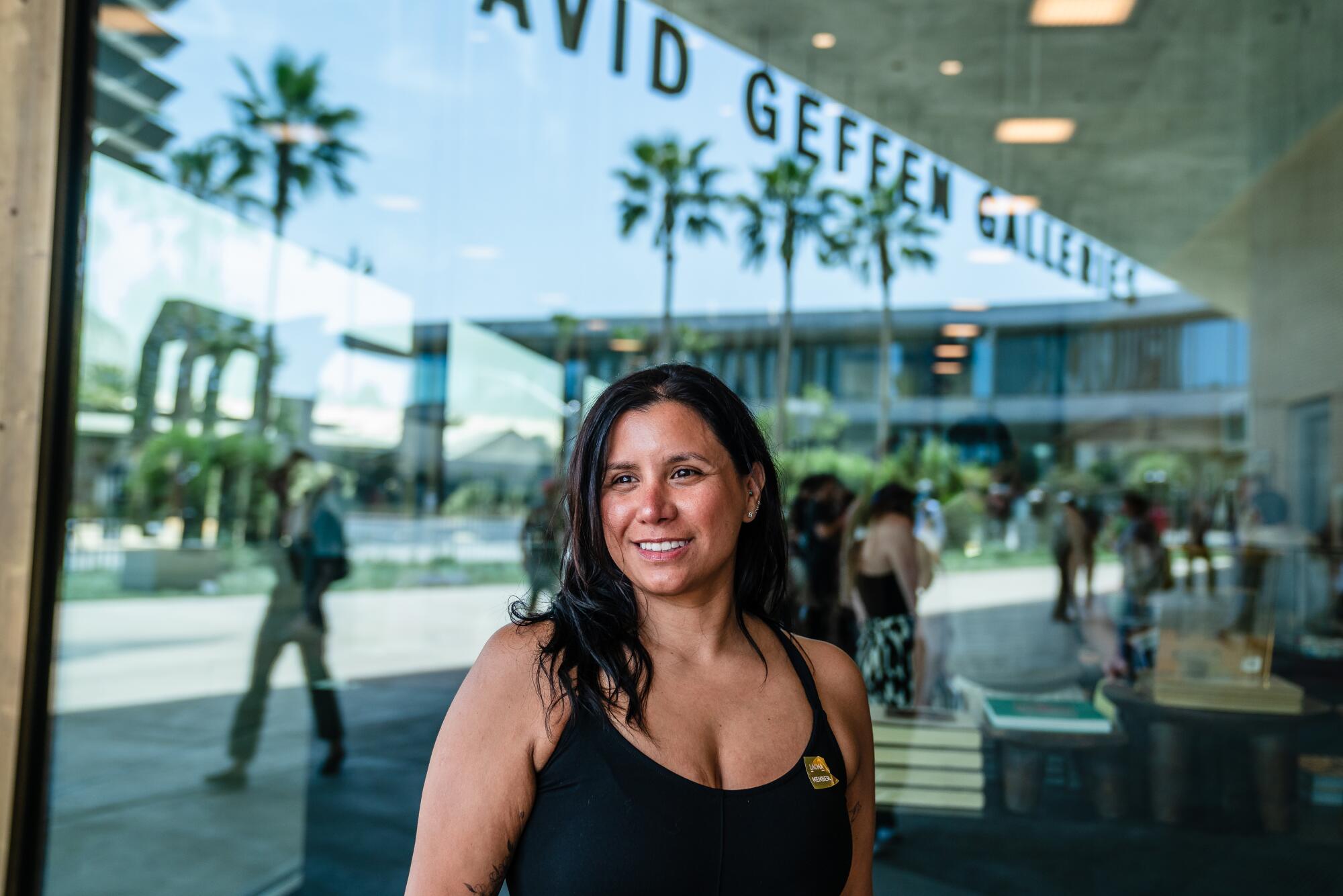 A woman stands in front of a cafe window.