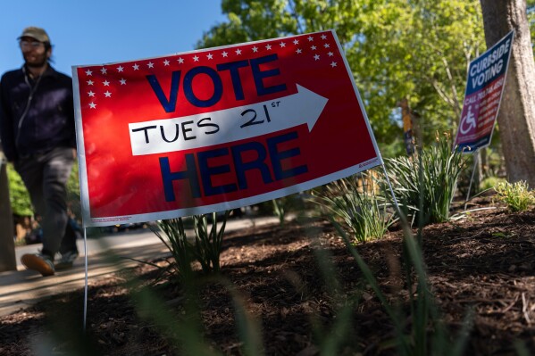 A person walks to vote in the Virginia redistricting referendum at Lyles-Crouch Traditional Academy, Tuesday, April 21, 2026, in Alexandria, Va. (AP Photo/Julia Demaree Nikhinson)