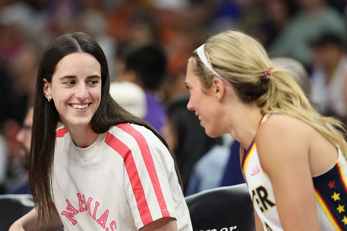 Caitlin Clark #22 of the Indiana Fever talks with Lexie Hull #10 on the bench