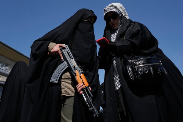 A woman member of the Basij paramilitary, affiliated with Iran's Revolutionary Guard, holds her gun during a state-organized rally in support of the supreme leader marking National Girl's Day in Tehran, Iran, Friday, April 17, 2026. (AP Photo/Vahid Salemi, File)