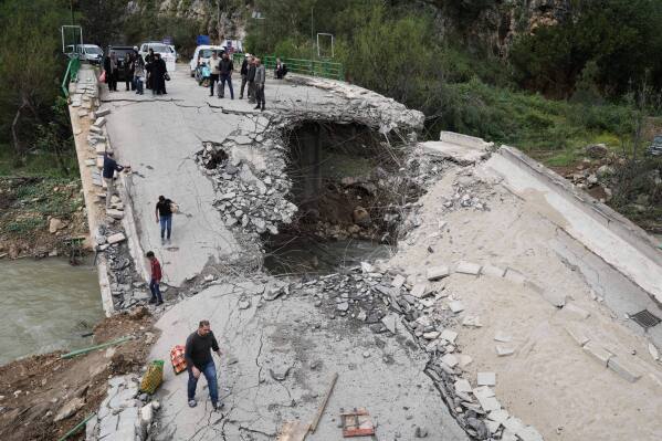 Displaced people cross a destroyed bridge as they return to their villages, following a ceasefire between Hezbollah and Israel, in Tayr Felsay village, southern Lebanon, Sunday, April 19, 2026. (AP Photo/Bilal Hussein, File)