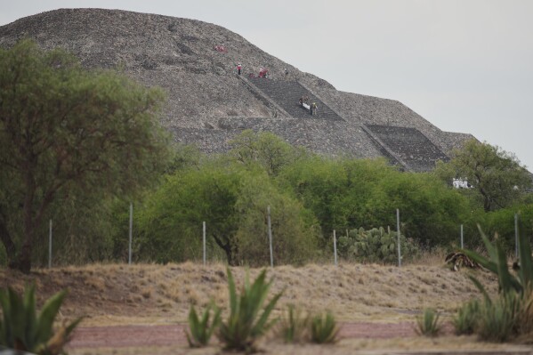 Forensic experts carry the body of a victim down a pyramid after authorities said a gunman opened fire, in Teotihuacan, Mexico, Monday, April 20, 2026. (AP Photo/Eduardo Verdugo, File)
