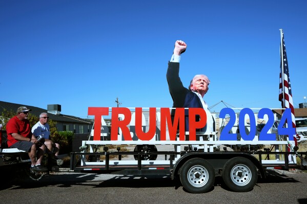 President Donald Trump supporters sit on a tailgate near the venue where the president is scheduled to speak later, Friday, April 17, 2026, in Phoenix. (AP Photo/Ross D. Franklin, File)