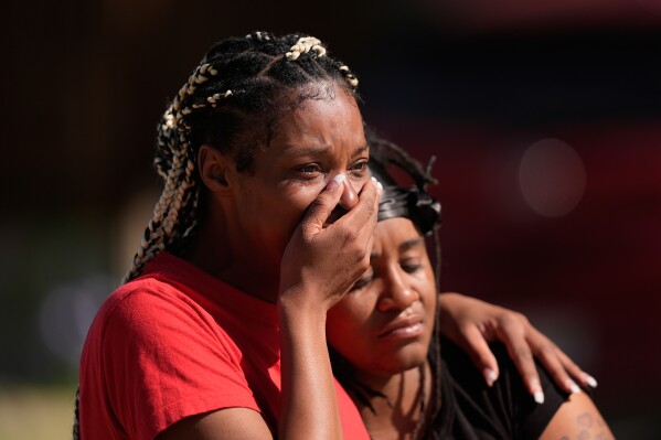 People comfort each other outside the scene of a mass shooting, Sunday, April 19, 2026, in Shreveport, La. (AP Photo/Gerald Herbert, File)