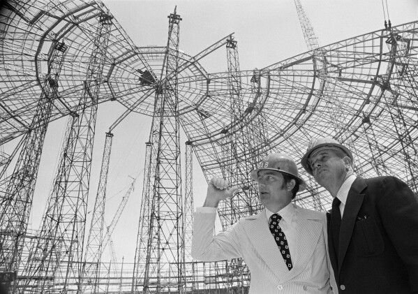 New York Mets general manager Robert Scheffing, right, chats with stadium official Bill Connick under the roof of the dome stadium that is under construction in New Orleans, April 2, 1973. (AP Photo/Jack Thornell, File)