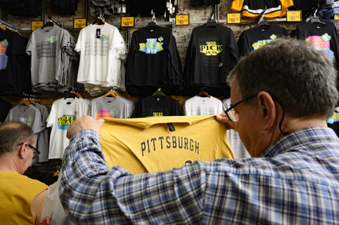 A customer looks at a Pittsburgh t-shirt at souvenir shop, Yinzers in the Burgh.