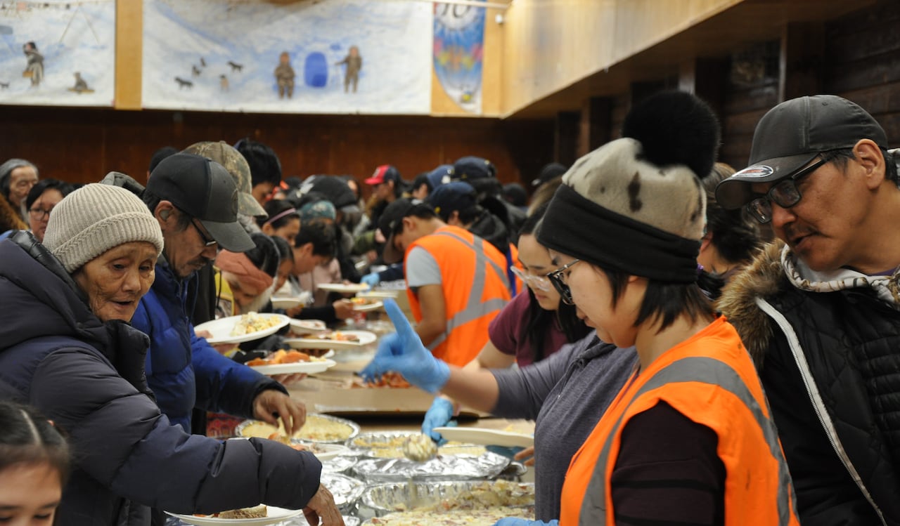 A large group of people take part in a community feast.