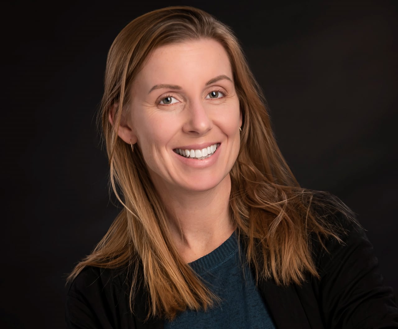 A woman stands with her arms crossed.