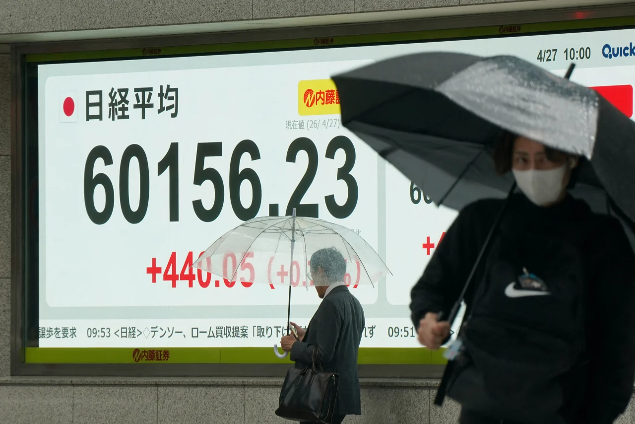 People walk past an electronic quotation board displaying the Nikkei Stock Average on the Tokyo Stock Exchange on Monday.