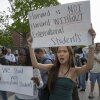 People hold up signs that say "Harvard is not Harvard without international students" and "We stand with international students" during a rally at the Harvard University campus in Boston on May 27.