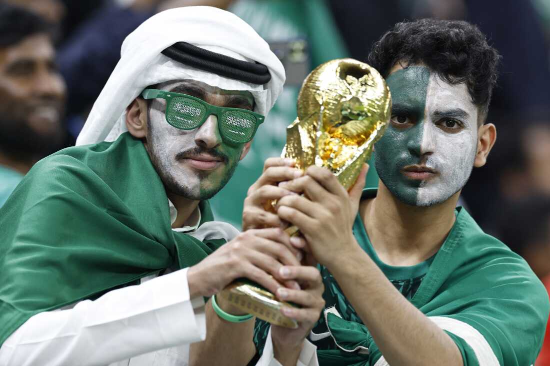 Saudi Arabia supporters hold a replica of the FIFA World Cup trophy ahead of a match between Saudi Arabia and Mexico in Lusail Stadium in Qatar during the 2022 World Cup.