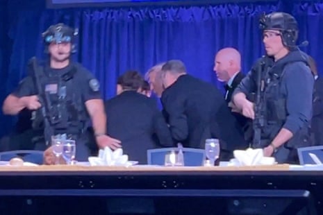 Donald Trump is escorted out as after shots were fired at the dinner event