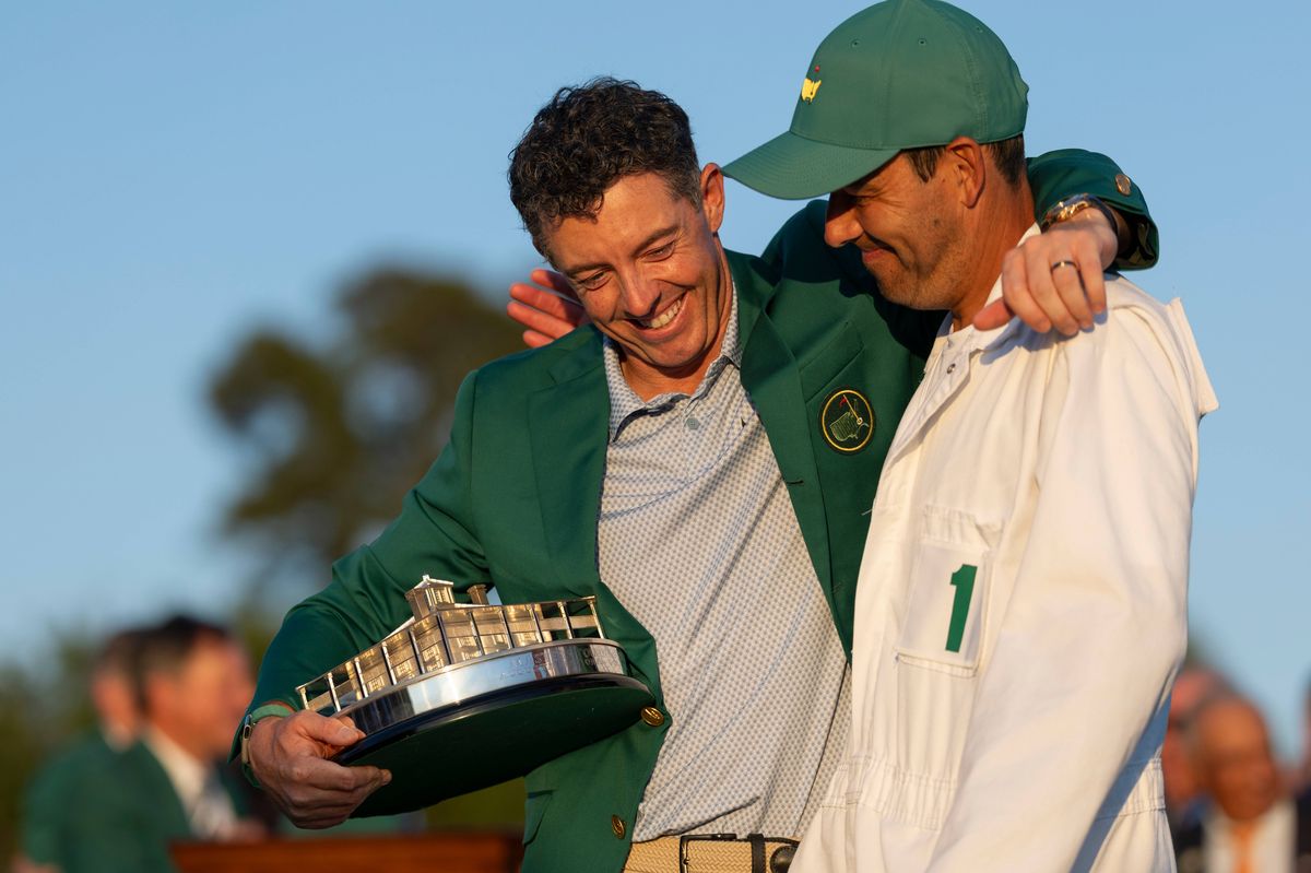 Masters champion Rory McIlroy of Northern Ireland celebrates with his caddie Harry Diamond during the Green Jacket Presentation Ceremony following the final round of the Masters at Augusta National Golf Club