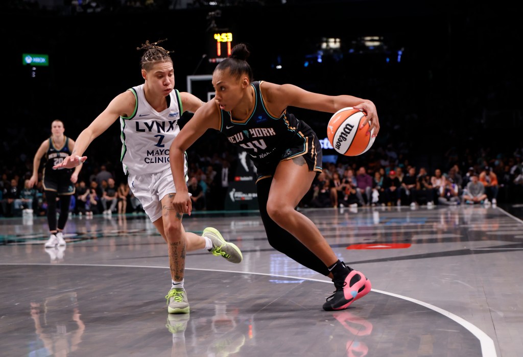 Betnijah Laney-Hamilton of the New York Liberty drives with the basketball, defended by Natisha Hiedeman of the Minnesota Lynx, during Game 5 of the 2024 WNBA Finals.