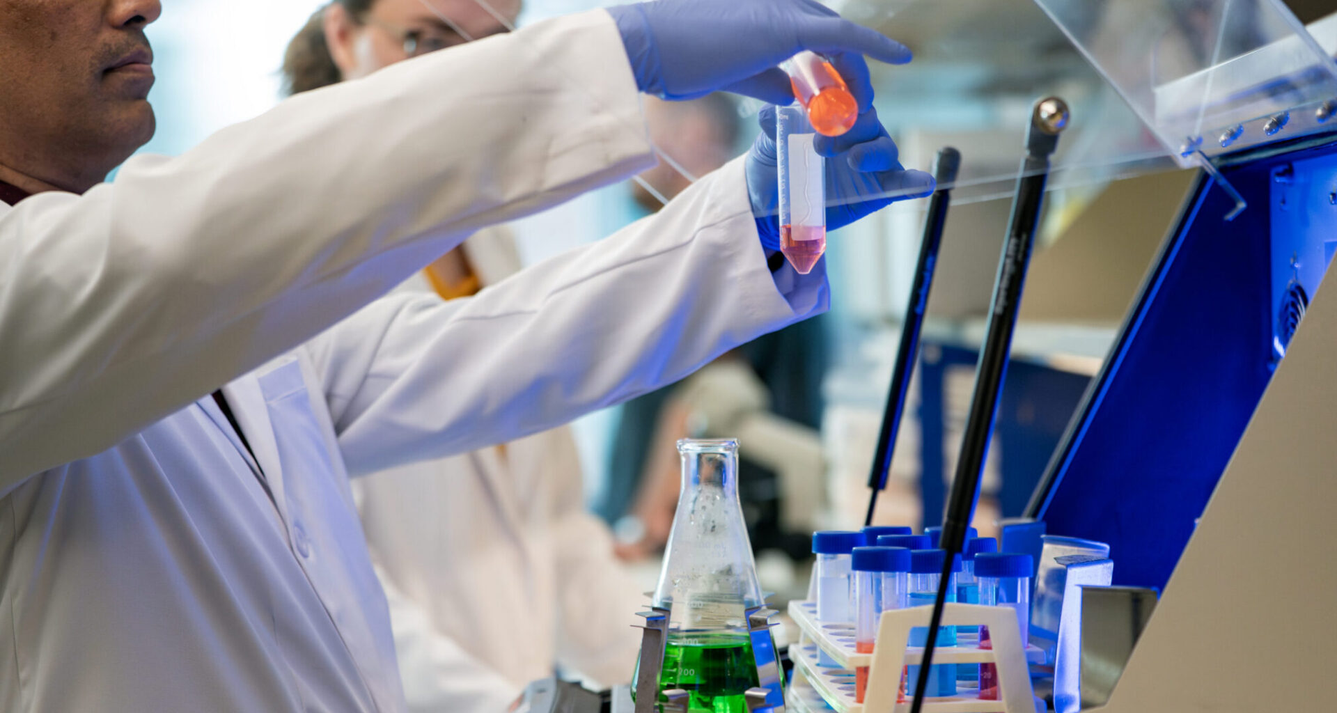 Scenes from the Shetty lab, with two students mixing two solutions into a centrifuge.